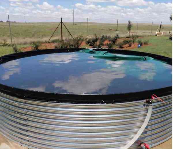 Filled galvanised steel farm dam